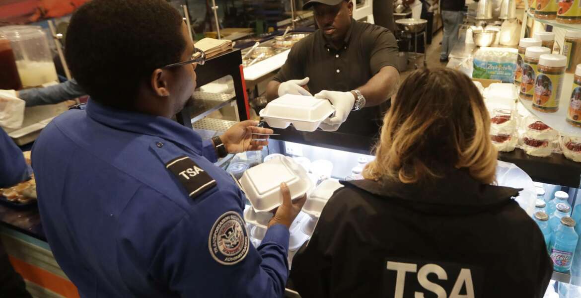 Chef Creole owner Wilkinson Sejour hands out free hot meals to TSA workers at his restaurant at Miami International Airport, Tuesday, Jan. 15, 2019, in Miami. The restaurant is offering free lunch and dinner to federal airport employees affected by the government shutdown. (AP Photo/Lynne Sladky)
