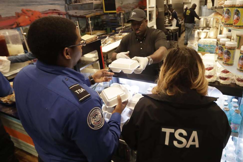 Chef Creole owner Wilkinson Sejour hands out free hot meals to TSA workers at his restaurant at Miami International Airport, Tuesday, Jan. 15, 2019, in Miami. The restaurant is offering free lunch and dinner to federal airport employees affected by the government shutdown. (AP Photo/Lynne Sladky)