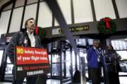 FILE - In this Tuesday, Jan. 8, 2019, file photo, Federal Aviation Administration employee Michael Jessie, who is currently working without pay as an aviation safety inspector for New York international field office overseeing foreign air carriers, holds a sign while attending a news conference at Newark Liberty International Airport in Newark, N.J. The FAA says it is calling 2,200 safety inspectors back to work by the end of this week. The inspectors certify work done by airlines, aircraft manufacturers and repair shops.  (AP Photo/Julio Cortez, File)