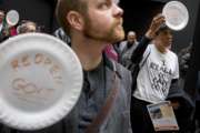 A furloughed government worker affected by the shutdown wears a shirt that reads "I Really Do Care Do U?" during a silent protest against the ongoing partial government shutdown on Capitol Hill in Washington, Wednesday, Jan. 23, 2019. Protesters held up disposable plates instead of posters to avoid being arrested. (AP Photo/Andrew Harnik)