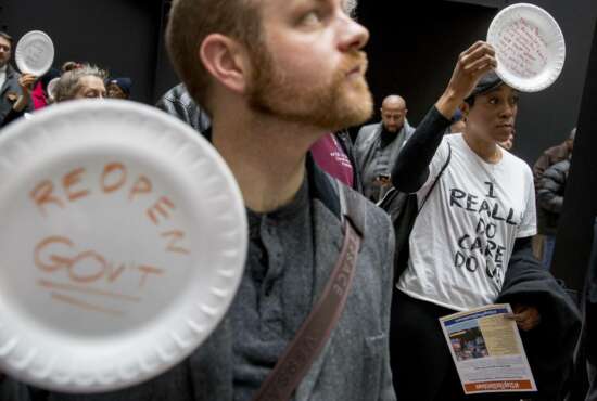 A furloughed government worker affected by the shutdown wears a shirt that reads 
