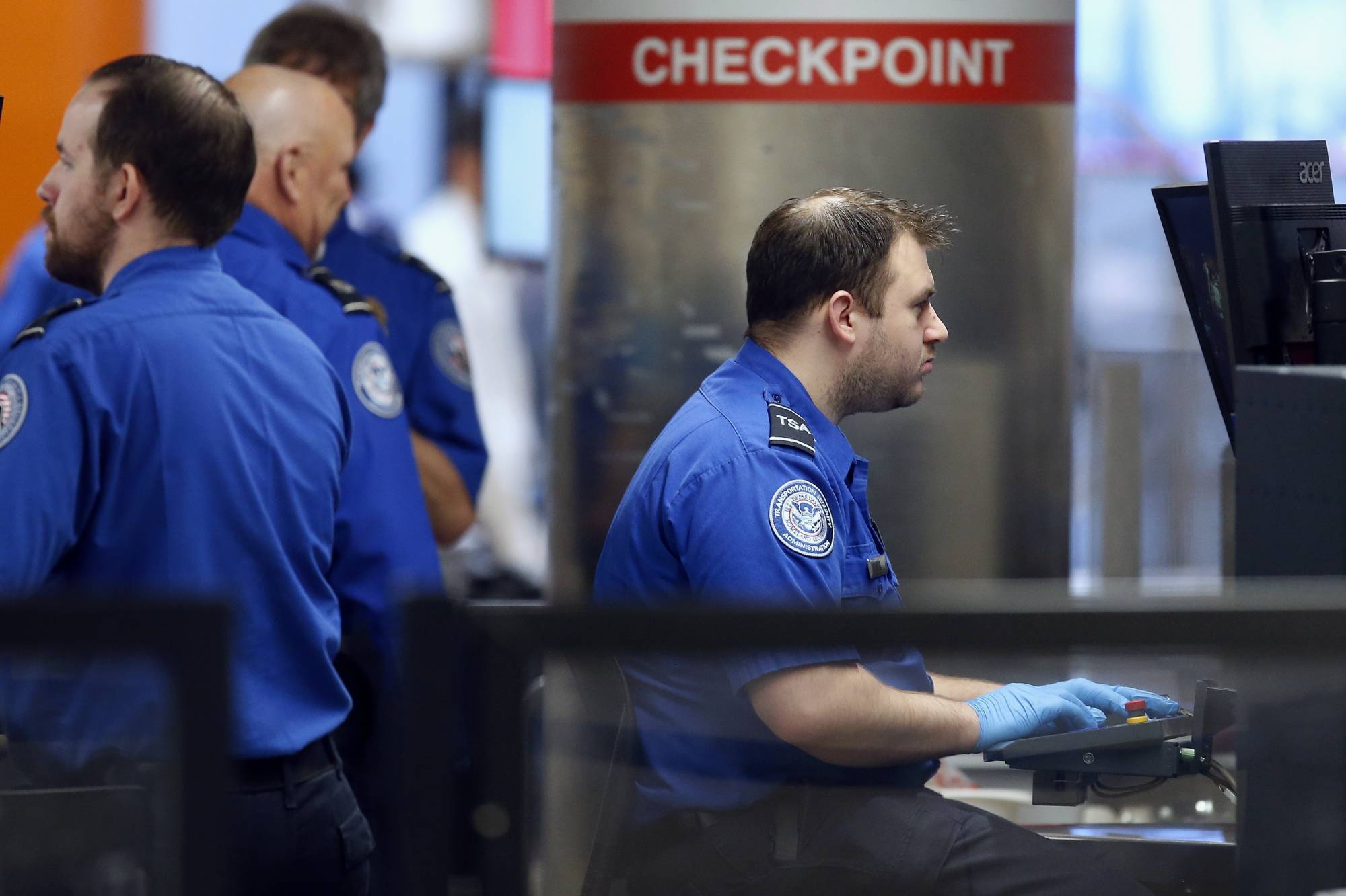 Transportation Security Administration officers work at a checkpoint at Logan International Airport in Boston, Saturday, Jan. 5, 2019. The TSA acknowledged an increase in the number of its employees calling off work during the partial government shutdown. (AP Photo/Michael Dwyer)