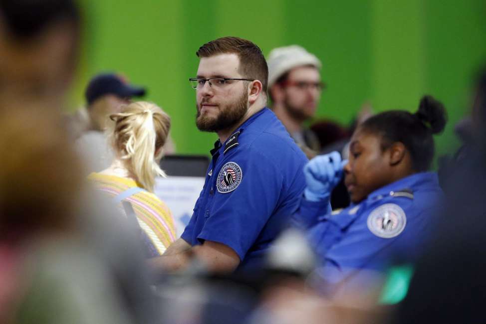 Transportation Security Administration officers work at a checkpoint at Logan International Airport in Boston, Saturday, Jan. 5, 2019. The TSA acknowledged an increase in the number of its employees calling off work during the partial government shutdown. (AP Photo/Michael Dwyer)