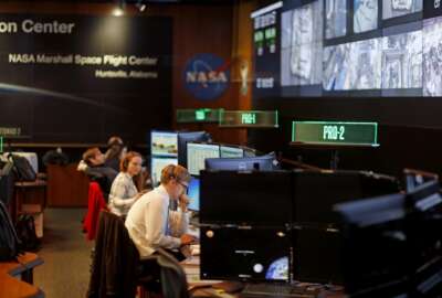 Workers monitor research operations aboard the International Space Station from NASA's Payload Operations Integration Center in Huntsville, Ala., Wednesday, Jan. 9, 2019. Of the roughly 800,000 federal employees facing deferred pay, more than half are deemed essential. (AP Photo/David Goldman)