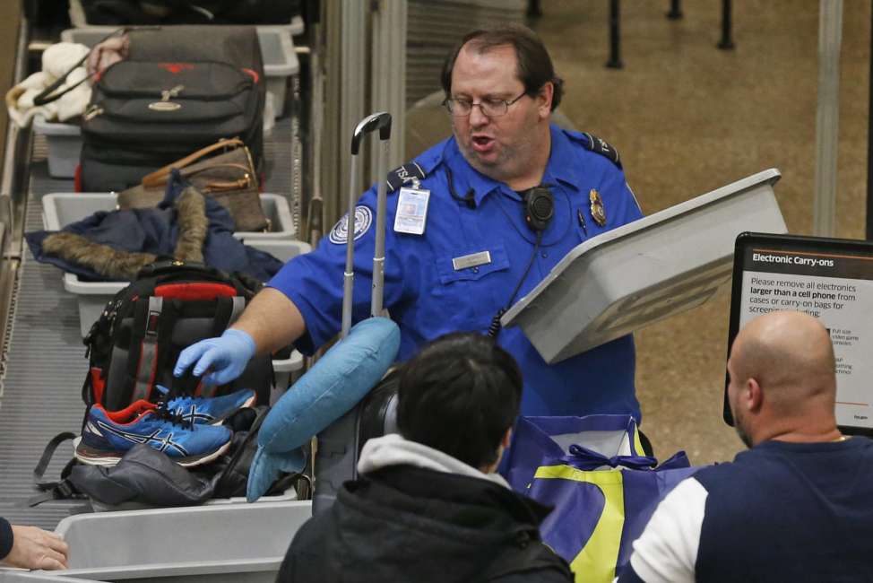 A TSA worker helps passengers at the Salt Lake City International Airport Wednesday Jan., 16, 2019, in Salt Lake City. The government shutdown has generated an outpouring of generosity to TSA agents and other federal employees who are working without pay. In Salt Lake City, airport officials treated workers from the TSA, FAA and Customs and Border Protection to a free barbecue lunch as a gesture to keep their spirits up during a difficult time. (AP Photo/Rick Bowmer)