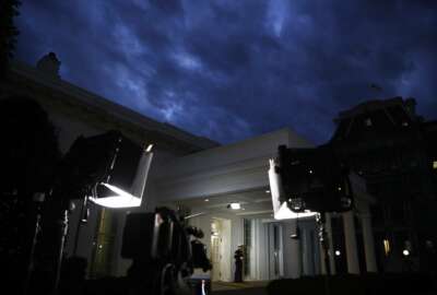 A Marine stands by the door to the West Wing of the White House, Tuesday Jan. 8, 2019, in Washington, as television lights are at the ready a few hours before President Donald Trump is expected to make an address to the nation. (AP Photo/Jacquelyn Martin)