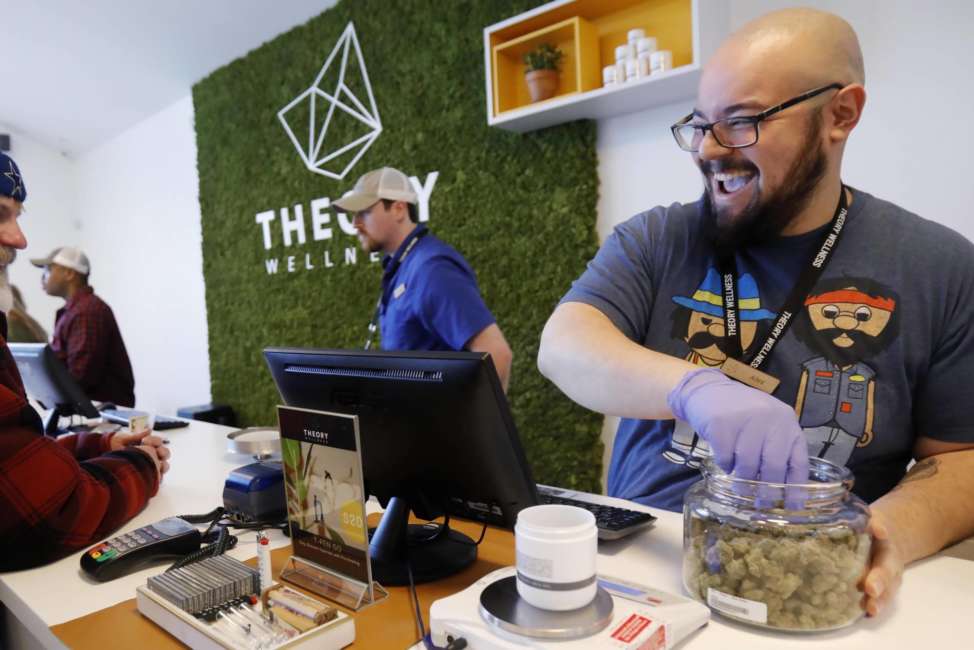 FILE - In this Jan. 11, 2019 file photo, Alex Premoli makes the first sale to a customer on the opening day of recreational marijuana sales at Theory Wellness in Great Barrington, Mass. New York legislators will be able to look toward their neighboring state, who became the latest state to legalize the recreational use of marijuana, for tips on how regulate and tax its use. (Stephanie Zollshan/The Berkshire Eagle via AP, File)