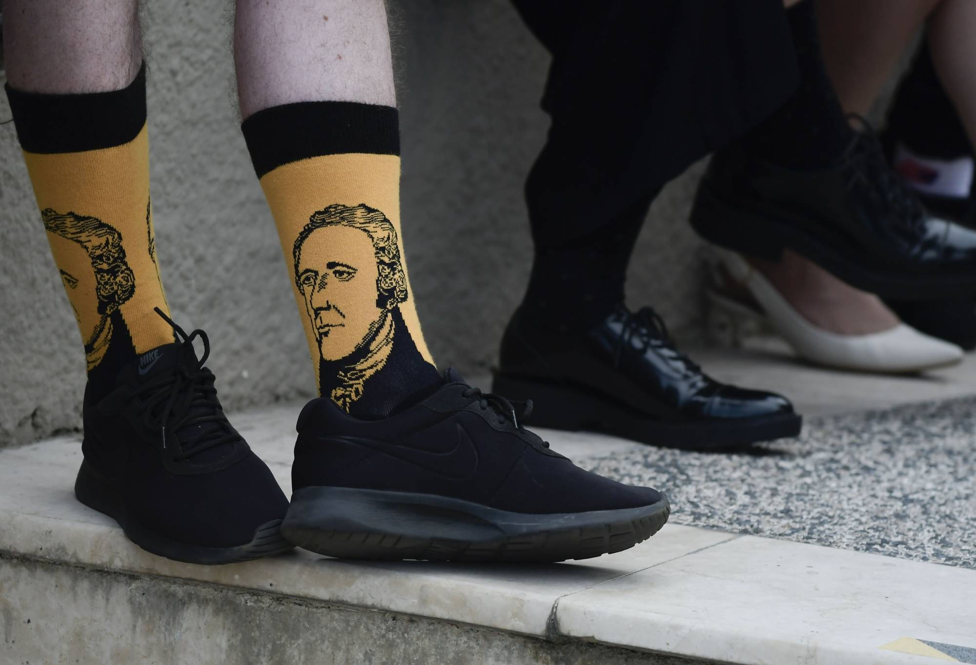 Scotland national Paul Mcque wears Hamilton socks in the entrance plaza of the Santurce Fine Arts Center moments before the premiere of the award-winning Broadway musical, Hamilton, starring its creator, New York native of Puerto Rican descent Lin-Manuel Miranda, in San Juan, Puerto Rico, Friday Jan. 11, 2019. The musical is set to run for two weeks and will raise money for local arts programs. (AP Photo/Carlos Giusti)