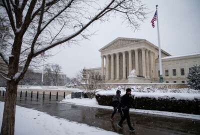 WASHINGTON, DC - JANUARY 13: People walk by a snow covered Supreme Court on January 13, 2019 in Washington, DC. The DC area was hit with 4-7 inches of snow accumulation with the potential of another 2-4 inches. President Donald Trump is holding off from a threatened national emergency declaration to fund a border wall amidst the longest partial government shutdown in the nation's history.  (Photo by Al Drago/Getty Images)
