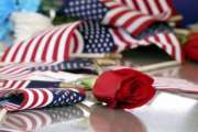 In this Jan. 17, 2019 photo, a rose lies on one of the caskets as hundreds of people showed up to bury three Memphis veterans, Wesley Russell, 76, Arnold Klechka, 71, Charles Fox, 60, who died this past fall and whose remains were unclaimed in Memphis, Tenn. (AP Photo/Karen Pulfer Focht)