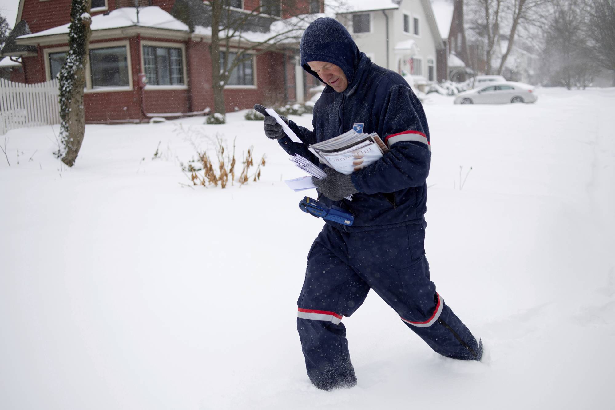 United States Postal Service letter carrier Keith Caniff sorts mail on his route in East Grand Rapids, Mich., Monday, Jan. 28, 2019. (Neil Blake/The Grand Rapids Press via AP)