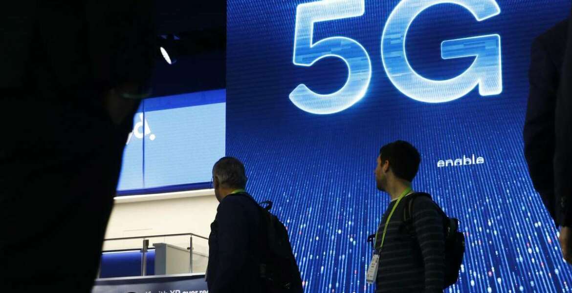 FILE- In this Jan. 9, 2019, file photo a sign advertises 5G at the Qualcomm booth at CES International in Las Vegas. 5G is a new technical standard for wireless networks that promises faster speeds; less lag, or “latency,” when connecting to the network; and the ability to connect many devices to the internet without bogging it down. (AP Photo/John Locher, File)