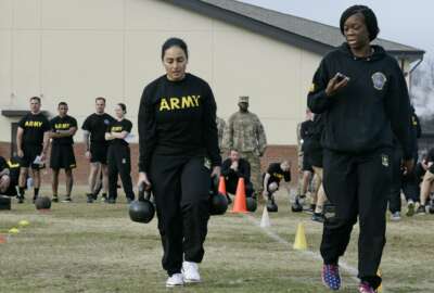 In this  Jan. 8, 2019, photo, U.S Army Staff Sgt. Idis Arroyo,left, carries weights while training to serve as an instructor in the new Army combat fitness test at Fort Bragg, N.C. The new test is designed to be a more accurate test of combat readiness than the current requirements. (AP Photo/Gerry Broome)