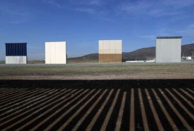 FILE - In this Wednesday, Dec. 12, 2018, file photo, border wall prototypes stand in San Diego near the Mexico-U.S. border, seen from Tijuana, Mexico, where the current wall casts a shadow in the foreground. Customs and Border Protection said Friday, Feb. 22, 2019, President Trump’s eight border-wall prototypes will be torn down to make way for a secondary barrier separating California from Mexico. (AP Photo/Moises Castillo, File)