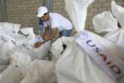 A Venezuelan volunteer places a bag of USAID humanitarian aid for storage at a warehouse next to the Tienditas International Bridge, near Cucuta, Colombia, on the border with Venezuela, Friday, Feb. 8, 2019. Trucks carrying U.S. humanitarian aid destined for Venezuela arrived Thursday at the Colombian border, where opposition leaders vowed to bring them into their troubled nation despite objections from embattled President Nicolas Maduro. (AP Photo/Fernando Vergara)