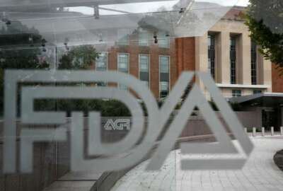 FILE - This Aug. 2, 2018 file photo shows the U.S. Food and Drug Administration building behind FDA logos at a bus stop on the agency's campus in Silver Spring, Md. The FDA announced plans Monday, Feb. 11, 2019, to step up its policing of dietary supplements, which it said has mushroomed into a $40 billion industry with more than 50,000 products. (AP Photo/Jacquelyn Martin)