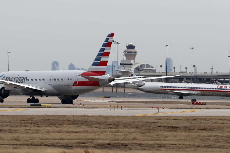 Jets line up on the tarmac at Dallas/Fort Worth International Airport in Grapevine, Dallas, Wednesday, Feb. 13, 2019. Flights at Dallas' two major airports were temporarily halted after air traffic controllers were forced to evacuate a building because of smoke, and the resulting flight delays are expected to continue for hours. (AP Photo/LM Otero)