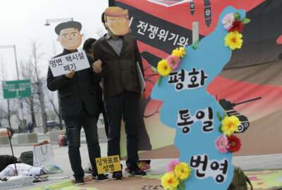 Protesters wearing masks of U.S. President Donald Trump and North Korean leader Kim Jong Un stand near the map of Korean Peninsula during a rally demanding the denuclearization of the Korean Peninsula and peace treaty near the U.S. embassy in Seoul, South Korea, Thursday, March 21, 2019. The Korean Peninsula remains in a technical state of war because the 1950-53 Korean War ended with an armistice, not a peace treaty. More than 20 protesters participated at a rally and also demanding the end the Korean War and to stop the sanction on North Korea. The letters read 