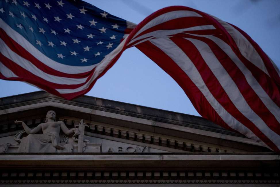 An American flag flies outside the Department of Justice in Washington, Friday, March 22, 2019. Special counsel Robert Mueller has concluded his investigation into Russian election interference and possible coordination with associates of President Donald Trump. The Justice Department says Mueller delivered his final report to Attorney Barr, who is reviewing it. (AP Photo/Andrew Harnik)