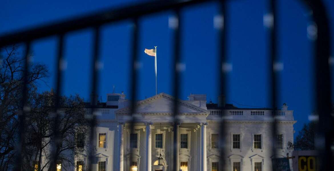 The White House is seen through a security fence, before sunrise, in Washington, Saturday, March 23, 2019. Special counsel Robert Mueller closed his long and contentious Russia investigation with no new charges, ending the probe that has cast a dark shadow over Donald Trump's presidency.  (AP Photo/Cliff Owen)