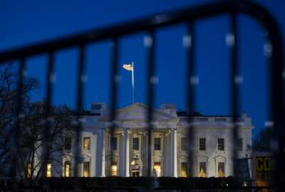 The White House is seen through a security fence, before sunrise, in Washington, Saturday, March 23, 2019. Special counsel Robert Mueller closed his long and contentious Russia investigation with no new charges, ending the probe that has cast a dark shadow over Donald Trump's presidency.  (AP Photo/Cliff Owen)