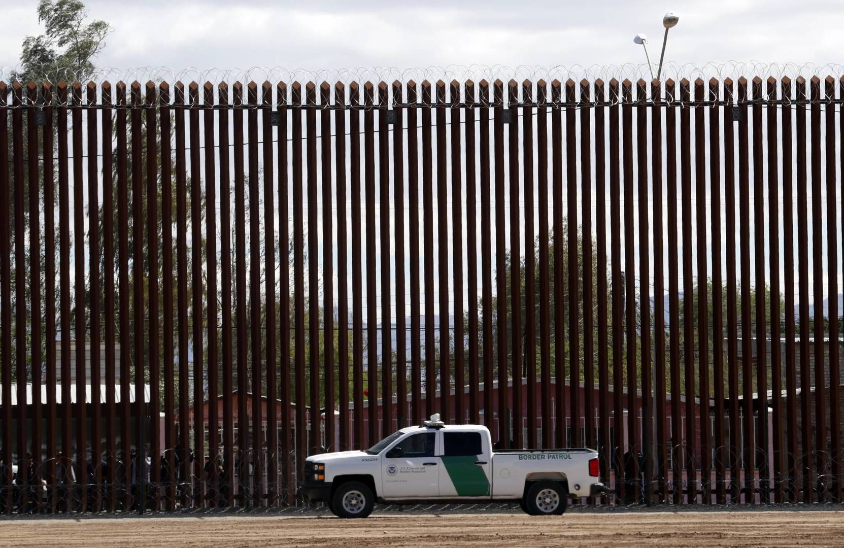 In this April 5, 2019, file photo, a U.S. Customs and Border Protection vehicle sits near the wall as President Donald Trump visits a new section of the border wall with Mexico in Calexico. Under pressure to show they have solutions, Democrats are honing proposals to address the surge of families entering the U.S. at the southern border, a problem they say Trump’s restrictive immigration policies are enflaming. (AP Photo/Jacquelyn Martin)