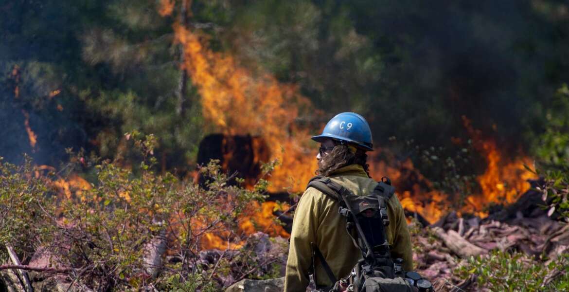 In this Sept. 4, 2018, photo, Tyler Medders of the Susanville Hot Shots keeps an eye out for embers at the North Fire near the North Fork Campgrounds in Placer County in Emigrant Gap, Calif. With nearly 40 million people living in California and development spreading into once-wild regions, some of the state's best tools toward preventing wildfires can't be widely used. Still, there is growing agreement that the state must step up its use of forest management through prescribed burns and vegetation removal in an attempt to lessen the impact of wildfires. (Jose Villegas/Sacramento Bee via AP)