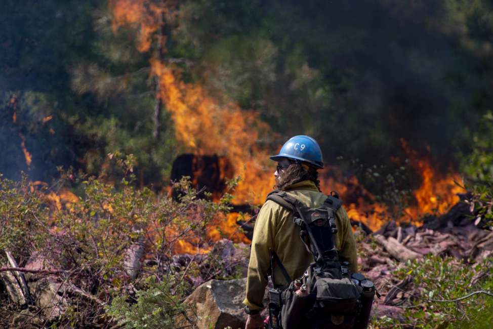 In this Sept. 4, 2018, photo, Tyler Medders of the Susanville Hot Shots keeps an eye out for embers at the North Fire near the North Fork Campgrounds in Placer County in Emigrant Gap, Calif. With nearly 40 million people living in California and development spreading into once-wild regions, some of the state's best tools toward preventing wildfires can't be widely used. Still, there is growing agreement that the state must step up its use of forest management through prescribed burns and vegetation removal in an attempt to lessen the impact of wildfires. (Jose Villegas/Sacramento Bee via AP)