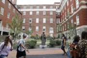 FILE - In this Sept. 1, 2016 file photo, students walk past a Jesuit statue in front of Isaac Hawkins Hall, center, formerly named Mulledy Hall, on the Georgetown University campus, in Washington. Georgetown University undergraduates have voted Thursday, April 11, 2019, in favor of a referendum seeking the establishment of a fund benefiting the descendants of enslaved people sold to pay off the school's debts. (AP Photo/Jacquelyn Martin, File)