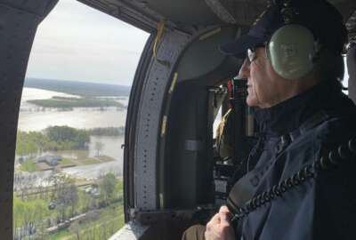 In this photo provided by the Mississippi Emergency Management Agency, Gov. Phil Bryant looks out at the backwater flooding surrounding the Valley Park community and neighboring farmland in Issaquena County, Miss. during a Wednesday, April 3, 2019 flyover by state and federal officials. (Ray Coleman/Mississippi Emergency Management Agency via AP)