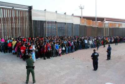 This May 29, 2019 photo released by U.S. Customs and Border Protection (CBP) shows some of 1,036 migrants who crossed the U.S.-Mexico border in El Paso, Texas, the largest that the Border Patrol says it has ever encountered. Video shows them going under a chain-link fence to the U.S., where they waited for agents to come. The Border Patrol has encountered 180 groups of more than 100 people since October, compared to 13 during the previous 12-month period and two the year before. (U.S. Customs and Border Protection via AP)