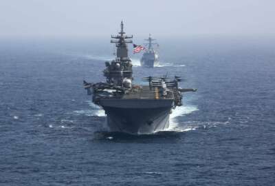 CORRECTS DATE - In this Friday, May 17, 2019, photo released by the U.S. Navy, the amphibious assault ship USS Kearsarge and the Arleigh Burke-class guided-missile destroyer USS Bainbridge sail in formation as part of the USS Abraham Lincoln aircraft carrier strike group in the Arabian Sea. Commercial airliners flying over the Persian Gulf risk being targeted by 