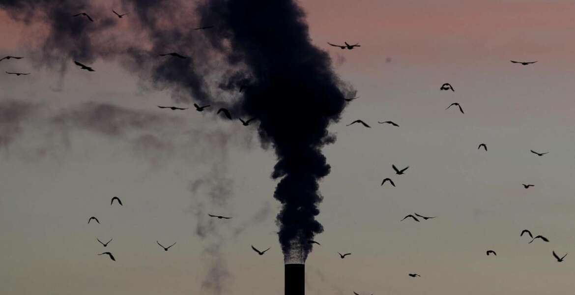 FILE - In this Dec. 4, 2018, file photo, birds fly past a smoking chimney in Ludwigshafen, Germany. Development that’s led to loss of habitat, climate change, overfishing, pollution and invasive species is causing a biodiversity crisis, scientists say in a new United Nations science report released Monday, May 6, 2019. (AP Photo/Michael Probst, File)
