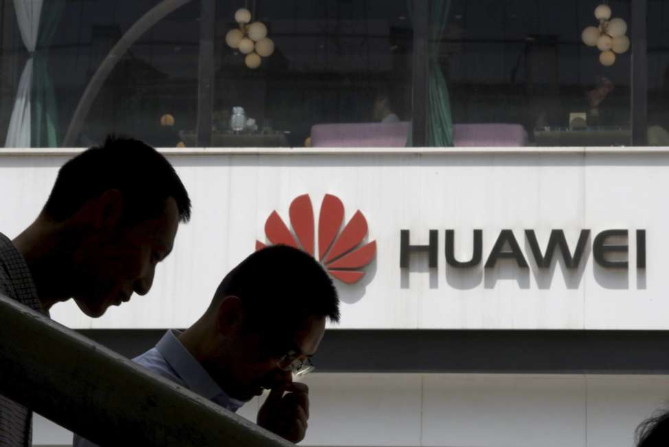 In this May 16, 2019, photo, Chinese men pass by a Huawei retail shop in Beijing. Stepping up the pressure on Beijing, the U.S. Commerce Department has effectively barred U.S. companies from selling or transferring technology to Huawei Technologies, the world's biggest maker of network gear, No. 2 smartphone manufacturer and a champion of Chinese industry. (AP Photo/Ng Han Guan)