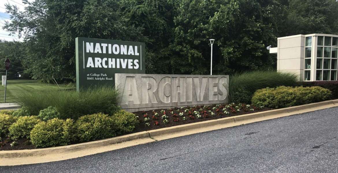 In this Tuesday, June 18, 2019 photo a sign for the entrance to the National Archives is seen in College Park, Md. A Virginia National Guard sergeant is accused of stealing World War II-era dog tags from the National Archives and Records Administration in Maryland, at least the second theft case involving the research facility. Robert Rumsby, of Fredericksburg, Va., told investigators he took dog tags that belonged to four U.S. airmen killed in plane crashes in 1944, according to a criminal complaint filed in federal court last month. (AP Photo/Michael Kunzelman)