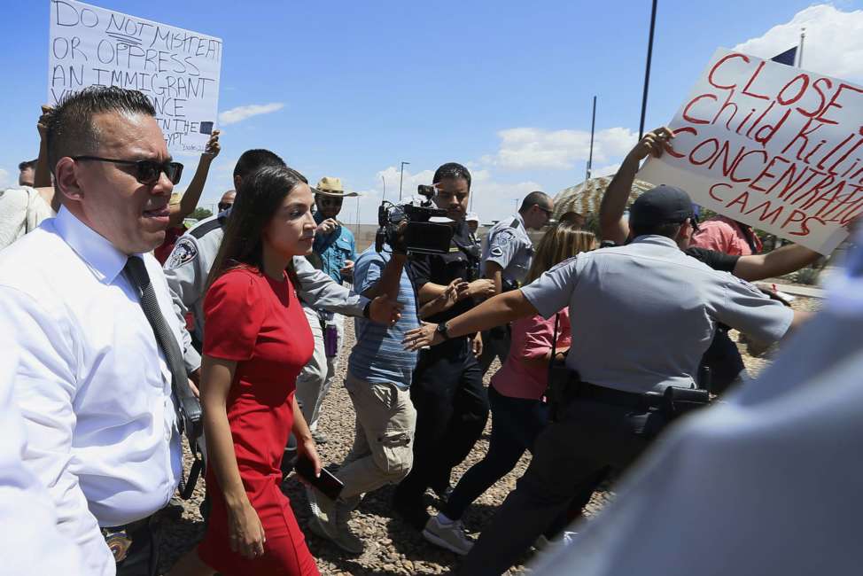 U.S. Rep. Alexandria Ocasio-Cortez, D-New York, is escorted back to her vehicle after she speaks at the Border Patrol station in Clint, Texas, about what she saw at area border facilities Monday, July 1, 2019. (Briana Sanchez/El Paso Times via AP)