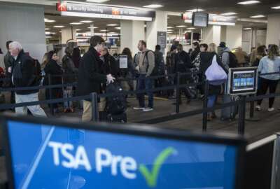FILE - In this Jan. 11, 2019, file photo, passengers wait in line at a Transportation Security Administration checkpoint at the Philadelphia International Airport in Philadelphia. The chief of the TSA said Monday, July 1, that travelers should see only a slight increase in checkpoint wait times over the four-day July 4 holiday weekend despite the diversion of about 350 employees including screeners to the U.S.-Mexico border. (AP Photo/Matt Rourke, File)