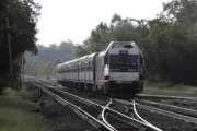 FILE- This Aug. 3, 2018, file photo shows a New Jersey Transit train leaving the Bound Brook Station in Bound Brook, N.J. Federal railway officials say the railroad industry has installed safety technology on nearly 90 percent of tracks where it is required, but “significant work” is needed to ensure the technology is completely installed by a December 2020 deadline. (AP Photo/Julio Cortez, File)