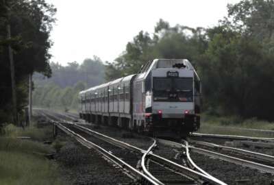 FILE- This Aug. 3, 2018, file photo shows a New Jersey Transit train leaving the Bound Brook Station in Bound Brook, N.J. Federal railway officials say the railroad industry has installed safety technology on nearly 90 percent of tracks where it is required, but “significant work” is needed to ensure the technology is completely installed by a December 2020 deadline. (AP Photo/Julio Cortez, File)