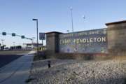 FILE - This Nov. 13, 2013 file photo shows the main gate of Camp Pendleton Marine Base at Camp Pendleton, Calif. A human smuggling investigation by the military led to the arrest of 16 Marines Thursday, July 25, 2019 while carrying out a battalion formation at California's Camp Pendleton, a base about an hour's drive from the U.S.-Mexico border. (AP Photo/Lenny Ignelzi, File)