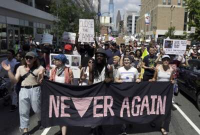 FILE - In this July 4, 2019, file photo, protesters assembled by a majority Jewish group called Never Again Is Now walk through traffic as they make their way to Independence Mall in Philadelphia. A fledgling coalition of liberal Jewish groups is increasingly making itself heard as it fights the Trump administration’s immigration policies. (AP Photo/Jacqueline Larma, File)