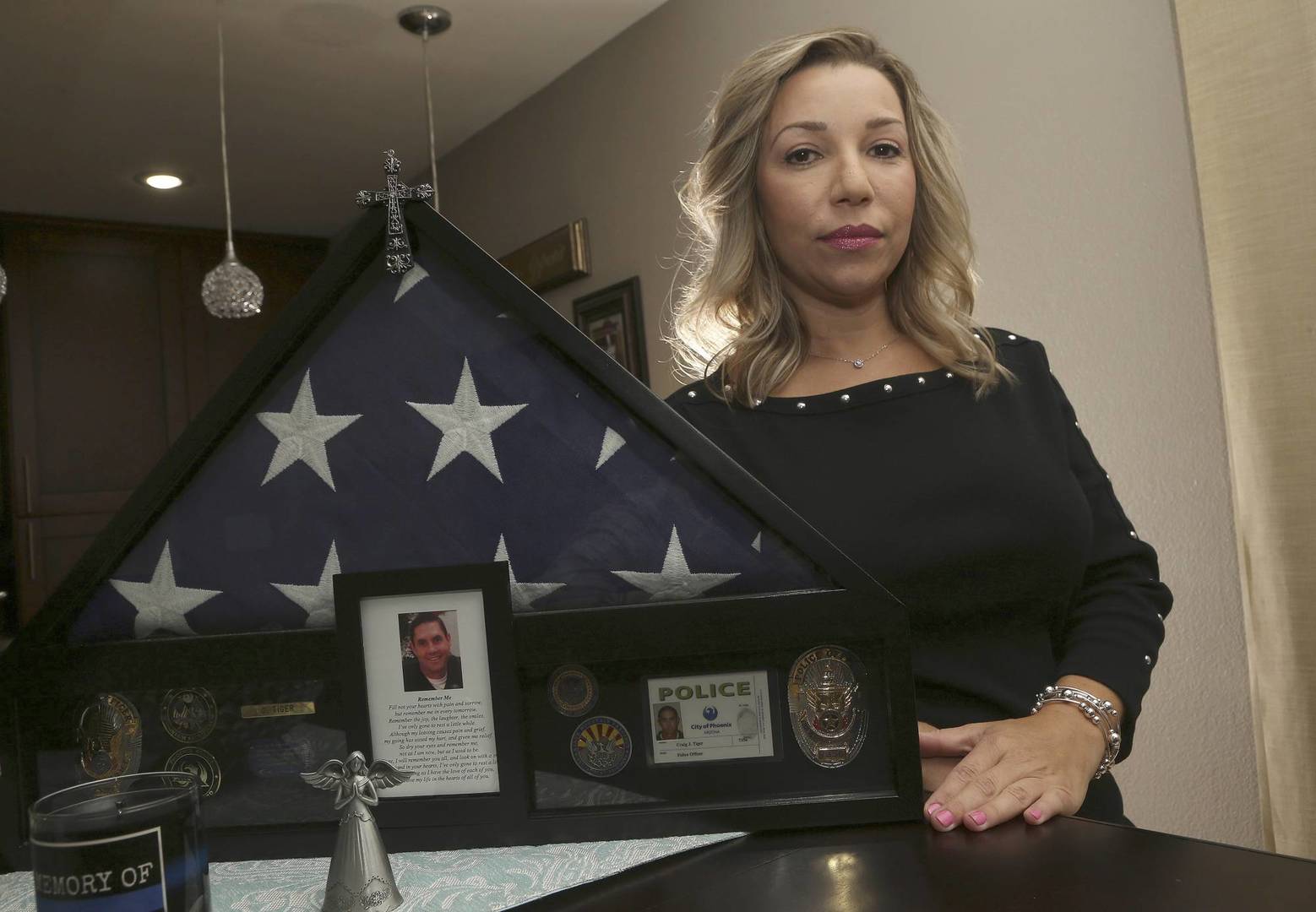 Rebecca Tiger, a former Phoenix police officer, is the widow of Craig Tiger, a Phoenix police officer who committed suicide a few years ago following a fatal shooting he was involved in, shown her home Monday, July 1, 2019, in Scottsdale, Ariz. Officer Craig Tiger suffered from post-traumatic stress disorder after fatally shooting a man while on duty back in 2012, and took his own life two years later. (AP Photo/Ross D. Franklin)