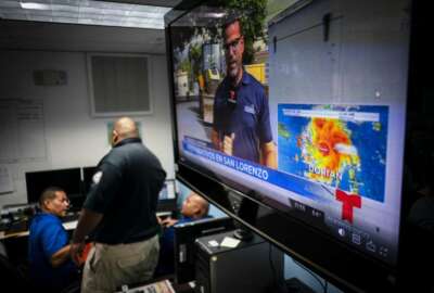 Emergency Center personnel stand next to a tv screen showing a meteorological image of the tropical storm Dorian, as they await its arrival, in Ceiba, Puerto Rico, Wednesday, Aug. 28, 2019. Puerto Rico is facing its first major test of emergency preparedness since the 2017 devastation of Hurricane Maria as Tropical Storm Dorian nears the U.S. territory at near-hurricane force.  (AP Photo/Ramon Espinosa)