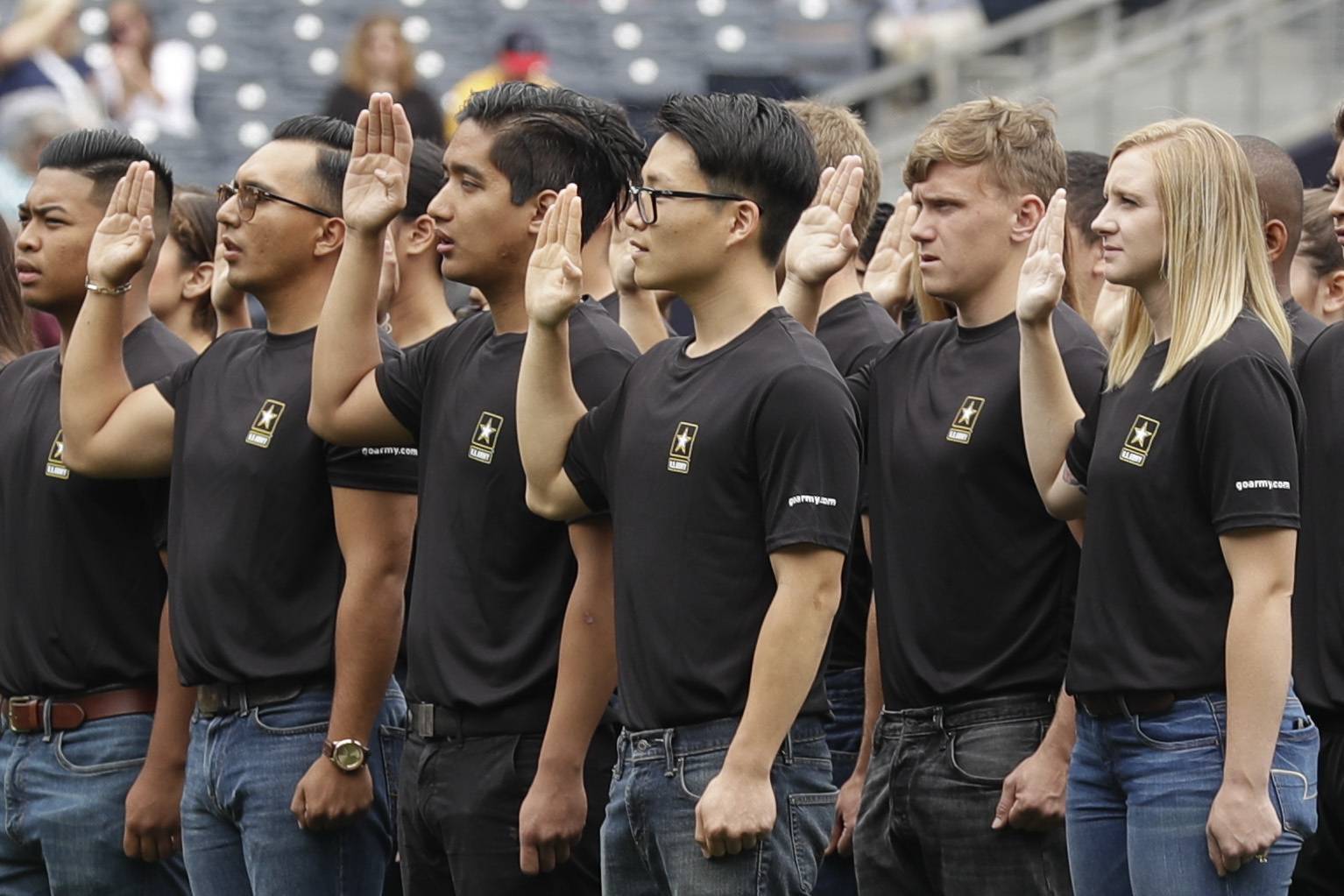 FILE - In this June 4, 2017, file photo. nNew Army recruits take part in a swearing in ceremony before a baseball game between the San Diego Padres and the Colorado Rockies in San Diego. A year after failing to meet its enlistment goal for the first time in 13 years, the U.S. Army is now on track to meet a lower 2019 target after revamping its recruitment effort. (AP Photo/Gregory Bull, File)