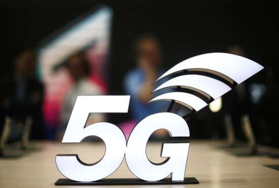 FILE - This Feb. 25, 2019 file photo shows a banner of the 5G network is displayed during the Mobile World Congress wireless show, in Barcelona, Spain.  The U.S. communications regulator will hold a massive auction to bolster 5G service, the next generation of mobile networks, and will spend $20 billion for rural internet.  5G will mean faster wireless speeds and has implications for technologies like self-driving cars and augmented reality.   The Federal Communications Commission said Friday, April 12,  that it would hold the largest auction in U.S. history, of 3,400 megahertz, to boost wireless companies’ networks.  (AP Photo/Manu Fernandez, File)