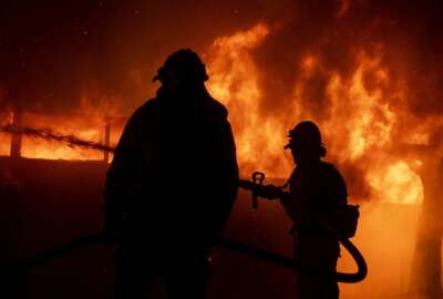 Firefighters try to save a home on Tigertail Road during the Getty fire, Monday, Oct. 28, 2019, in Los Angeles, Calif. (AP Photo/Christian Monterrosa)