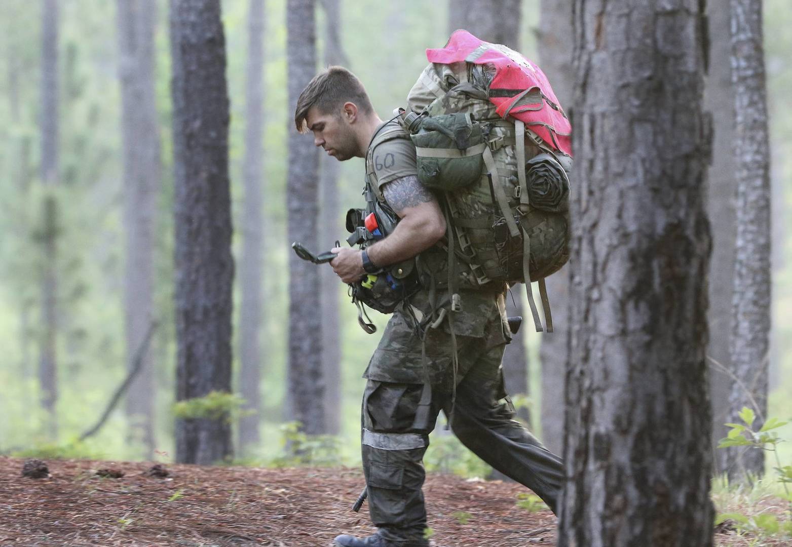 A soldier from the U.S. Army John F. Kennedy Special Warfare Center and School checks a compass while completing a land navigation course during Special Forces Assessment and Selection near Hoffman, N.C., May 7, 2019. Commanders are making big changes to the grueling course that soldiers must pass to join the elite Special Forces. The goal is to meet evolving national security threats and to shift from a culture that weeds out struggling soldiers to one that trains them to do better. (Ken Kassens/U.S. Army via AP)