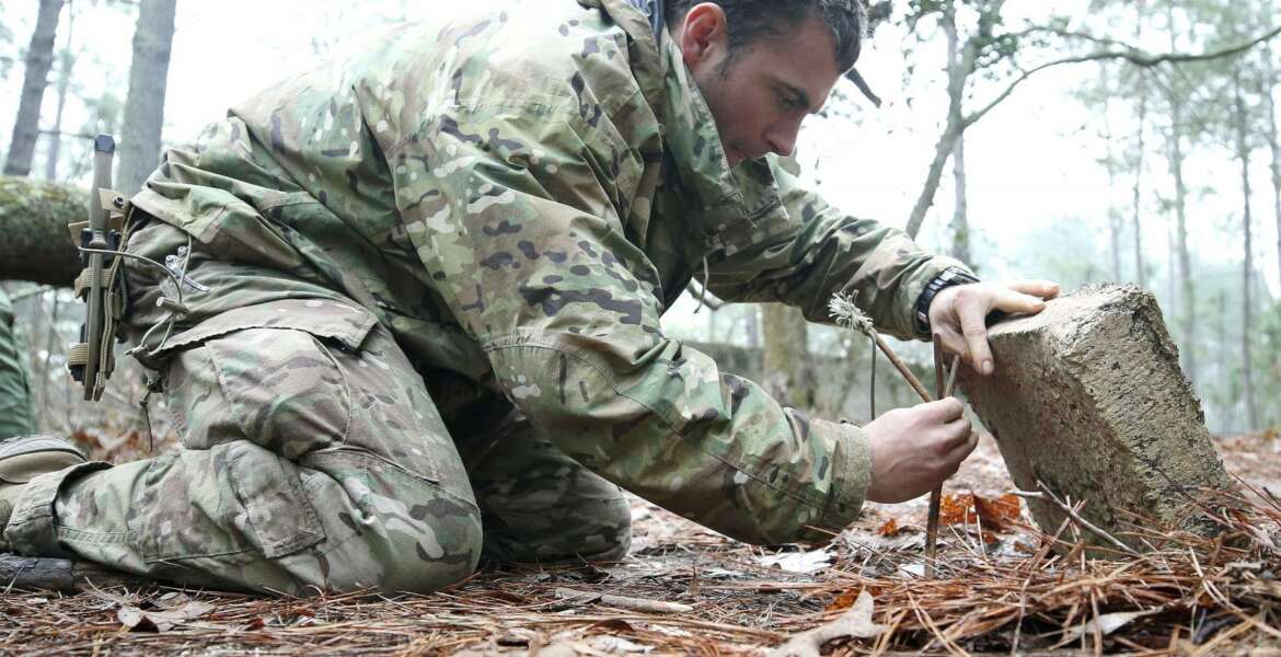 A student from the U.S. Army John F. Kennedy Special Warfare Center and School practices setting a paiute deadfall trap for small game during the survival phase of Survival Evasion Resistance and Escape Level-C training (SERE) at Camp Mackall, N.C., Feb. 28, 2019. Commanders are making big changes to the grueling course that soldiers must pass to join the elite Special Forces. The goal is to meet evolving national security threats and to shift from a culture that weeds out struggling soldiers to one that trains them to do better.(Ken Kassens/U.S. Army via AP)