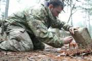 A student from the U.S. Army John F. Kennedy Special Warfare Center and School practices setting a paiute deadfall trap for small game during the survival phase of Survival Evasion Resistance and Escape Level-C training (SERE) at Camp Mackall, N.C., Feb. 28, 2019. Commanders are making big changes to the grueling course that soldiers must pass to join the elite Special Forces. The goal is to meet evolving national security threats and to shift from a culture that weeds out struggling soldiers to one that trains them to do better.(Ken Kassens/U.S. Army via AP)