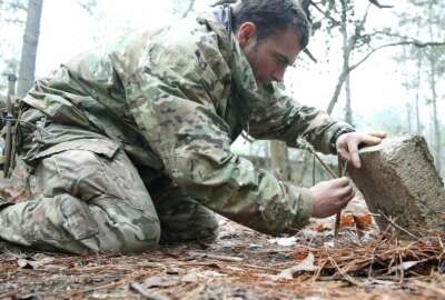 A student from the U.S. Army John F. Kennedy Special Warfare Center and School practices setting a paiute deadfall trap for small game during the survival phase of Survival Evasion Resistance and Escape Level-C training (SERE) at Camp Mackall, N.C., Feb. 28, 2019. Commanders are making big changes to the grueling course that soldiers must pass to join the elite Special Forces. The goal is to meet evolving national security threats and to shift from a culture that weeds out struggling soldiers to one that trains them to do better.(Ken Kassens/U.S. Army via AP)